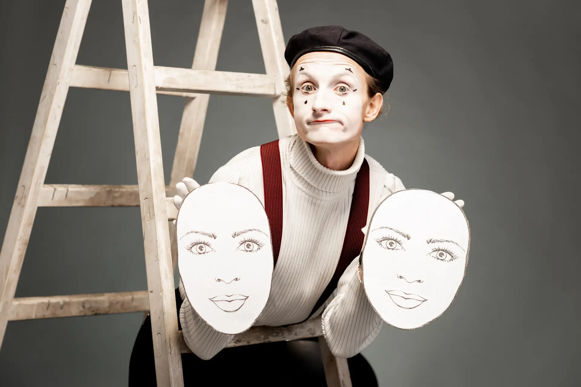 Portrait of an actor with facial masks on the grey background